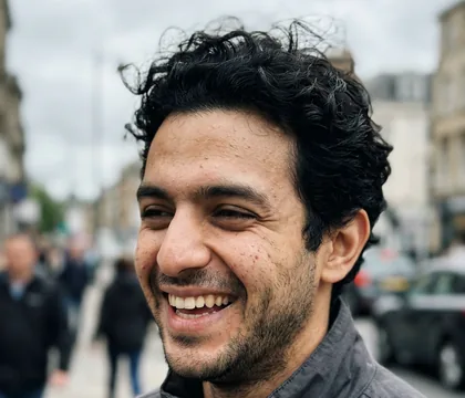 AI dating profile photo: headshot, laughing outdoors on an overcast day
