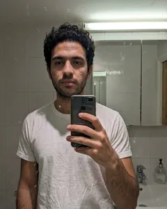 Input selfie: bathroom mirror shot taken on a phone